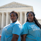 K’Vone Cropp, 26, left, and her twin sister Kayla Cropp, 26, of Richmond, Va., pose for a portrait while protesting with the group Students For Life, outside the Supreme Court about abortion, Wednesday, June 15, 2022, in Washington. “We aren’t big talkers,” said Kayla. “We are just here supporting the cause and abolishing abortion.”